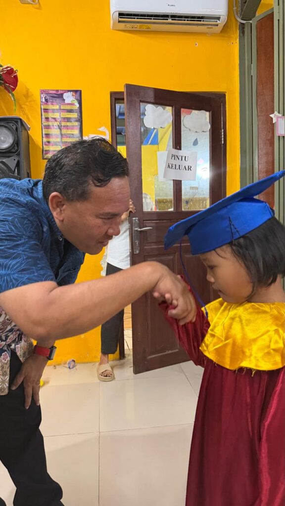 Foto kind wordt gefeliciteerd na slagen voor kleuterschool aan het einde van het schooljaar (juni 2026)